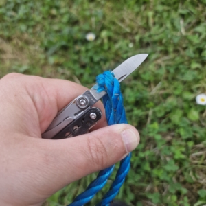 Photo of a Leatherman multi-tool cutting through some blue poly rope.