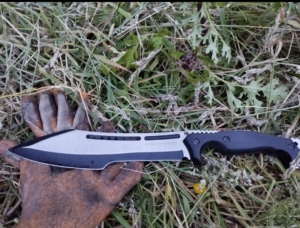 A photo of a machete being used to clean up a garden.