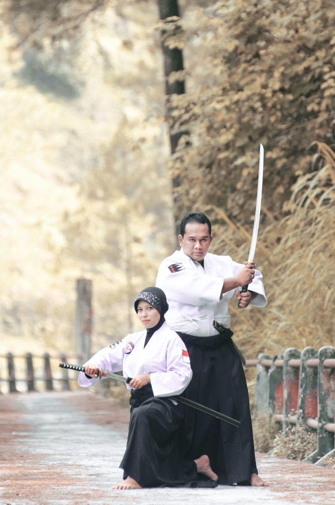 pair of martial artists posing with their Japanese swords. 